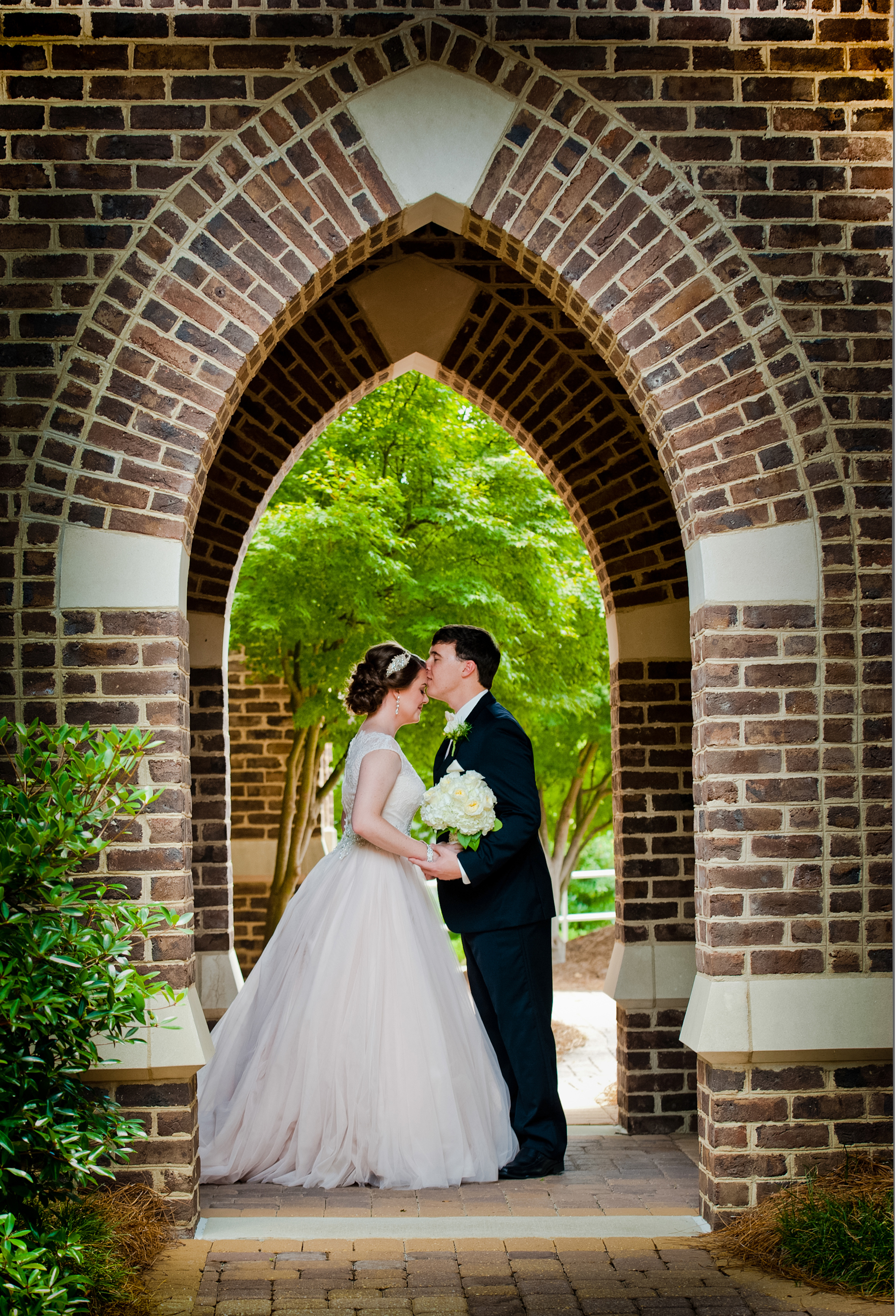 Bride and groom standing in an outdoor archway