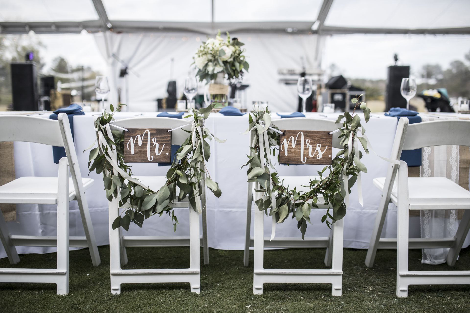 An image of a table at a reception with two decorated chairs