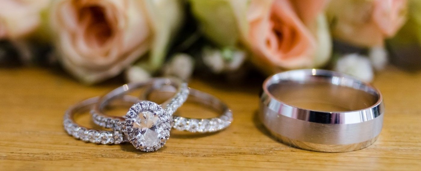 An Image of Brides engagement and wedding band and groom's wedding band siiting on a table